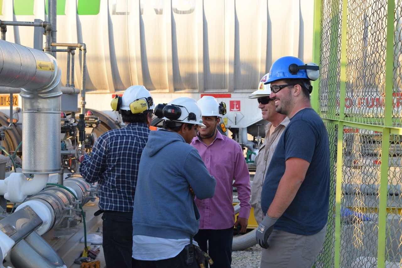Ingenieros de Okra Energy con cascos conversando en la planta