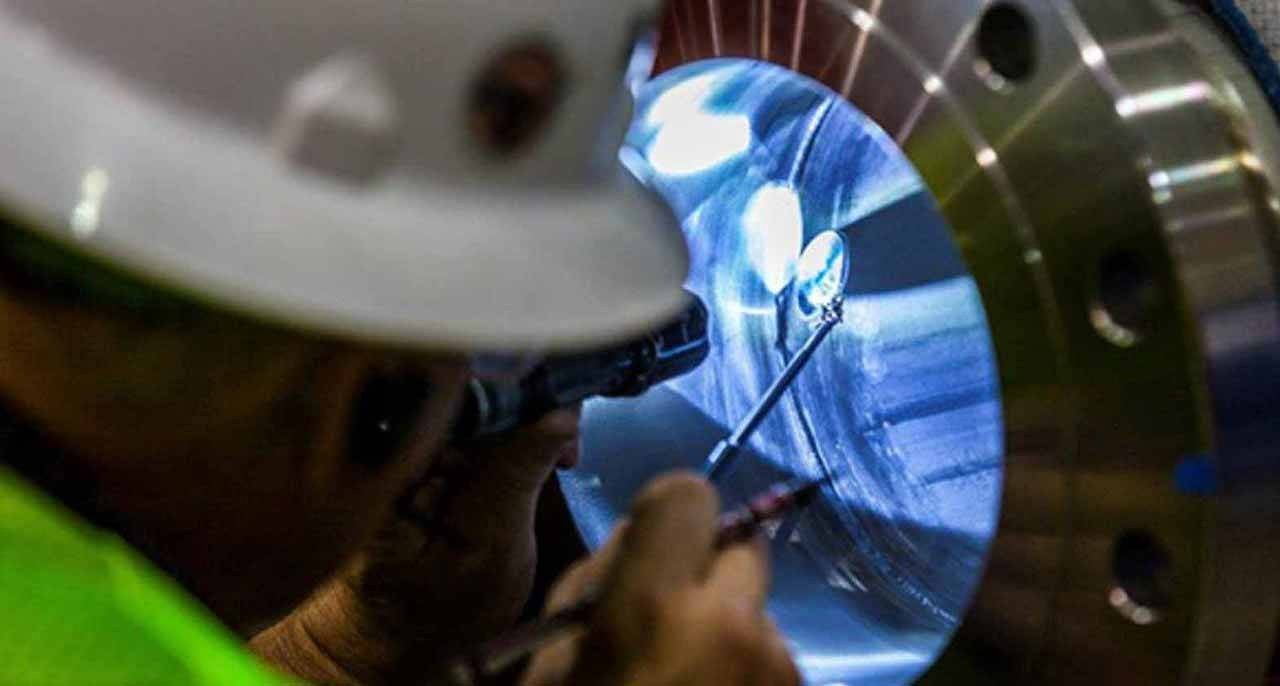 Un técnico inspecciona con un espejo el interior de una boquilla criogénica