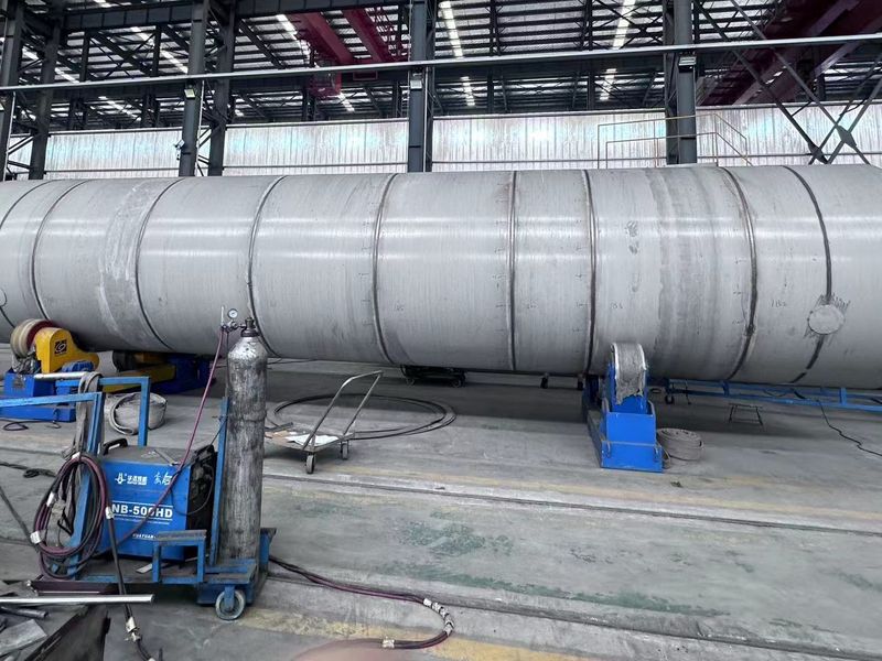 Stainless-steel inner vessel on turning rolls, with welding equipment